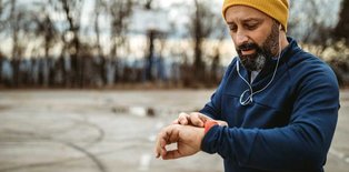 Man checking heart rat eon watch after jogging