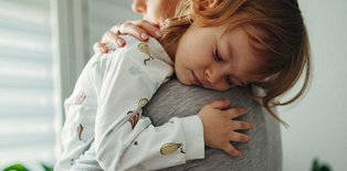 Child sleeping on parents shoulder