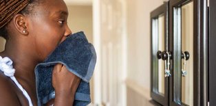 Teenager washing face in mirror